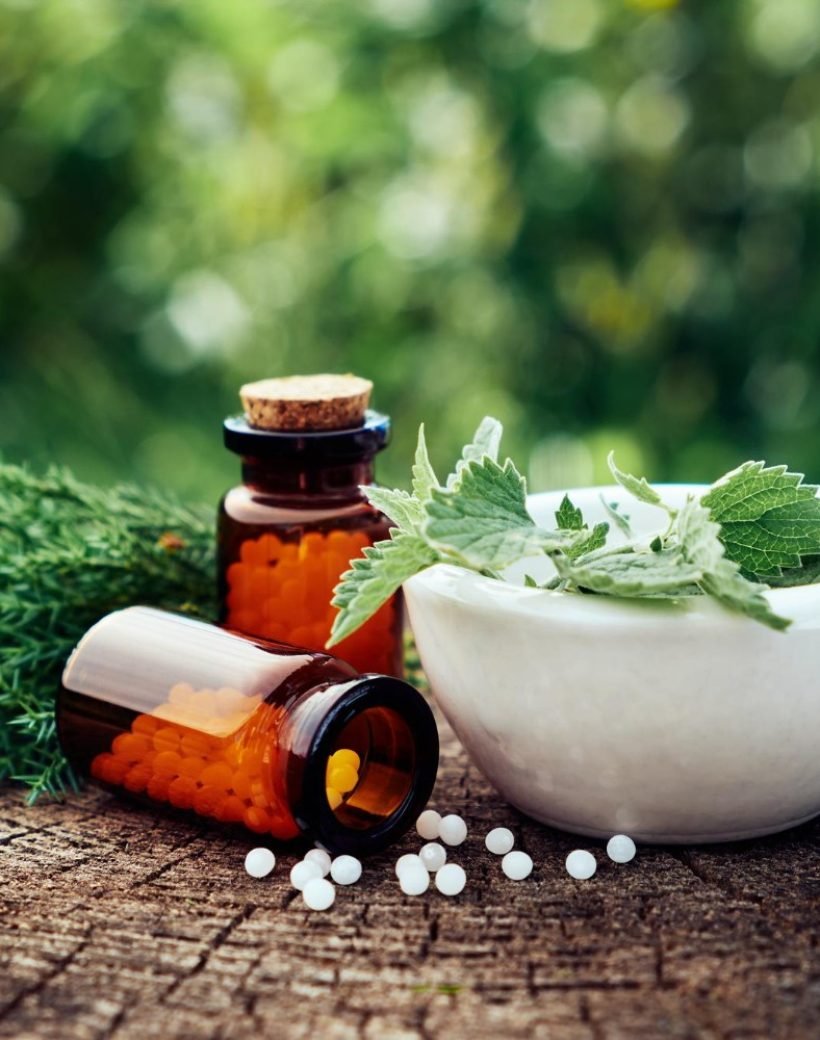 bottle-homeopathic-globules-mortar-green-nettle-mint-leaves-juniper-twigs-homeopathy